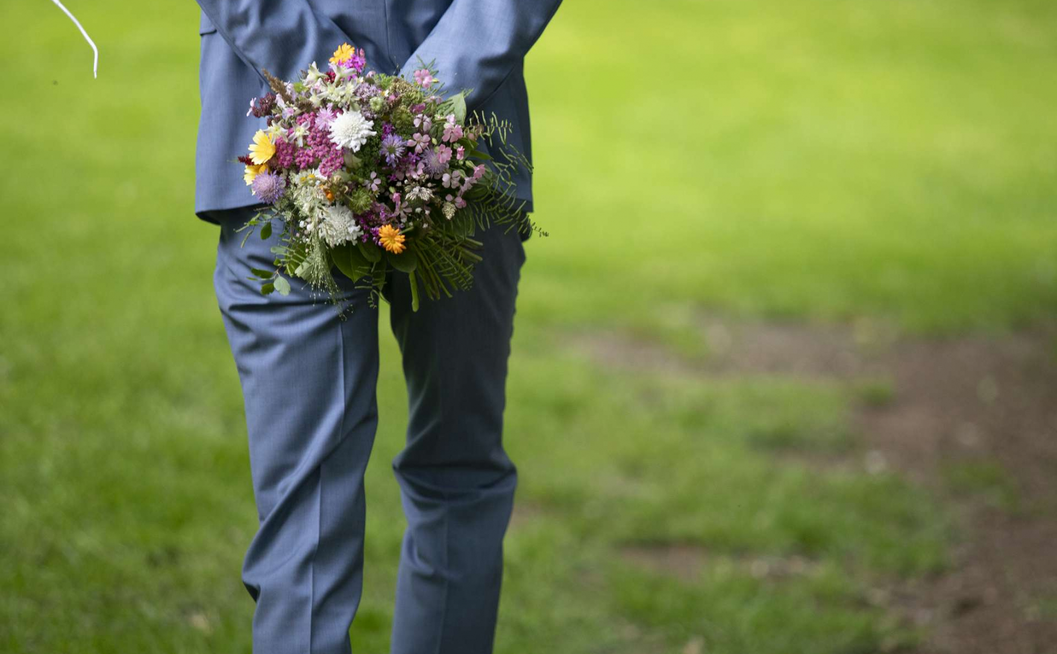 Mann mit Anzug und Blumenstrauß