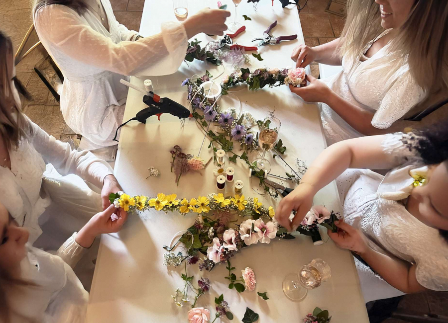 Frauen sitzen am Tisch und binden Blumen