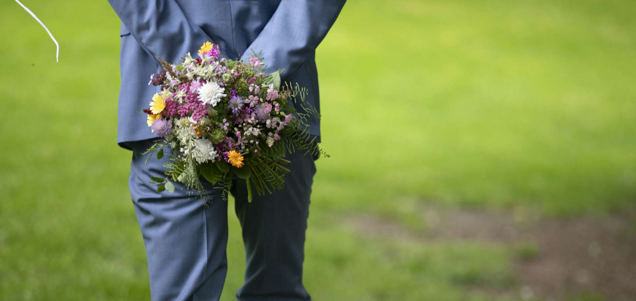 Mann mit Anzug und Blumenstrauß
