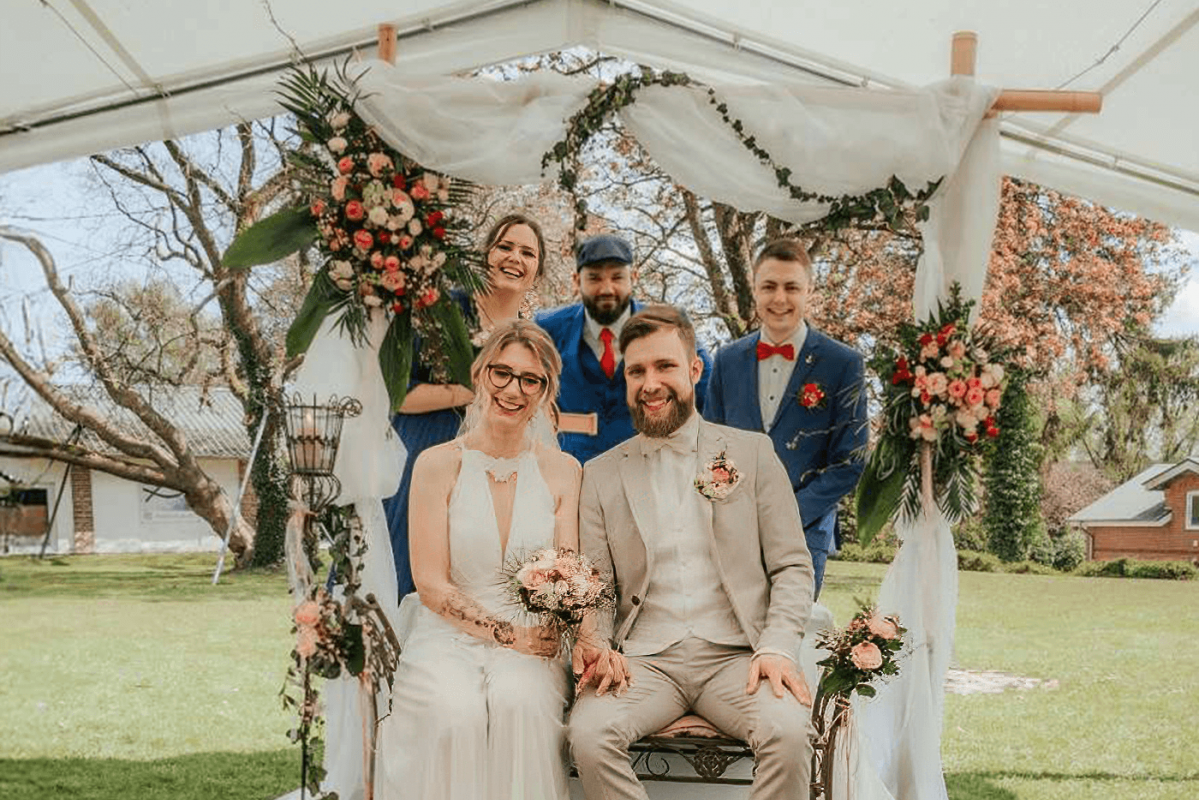 Braut, Bräutigam und Freunde unter Pavillion